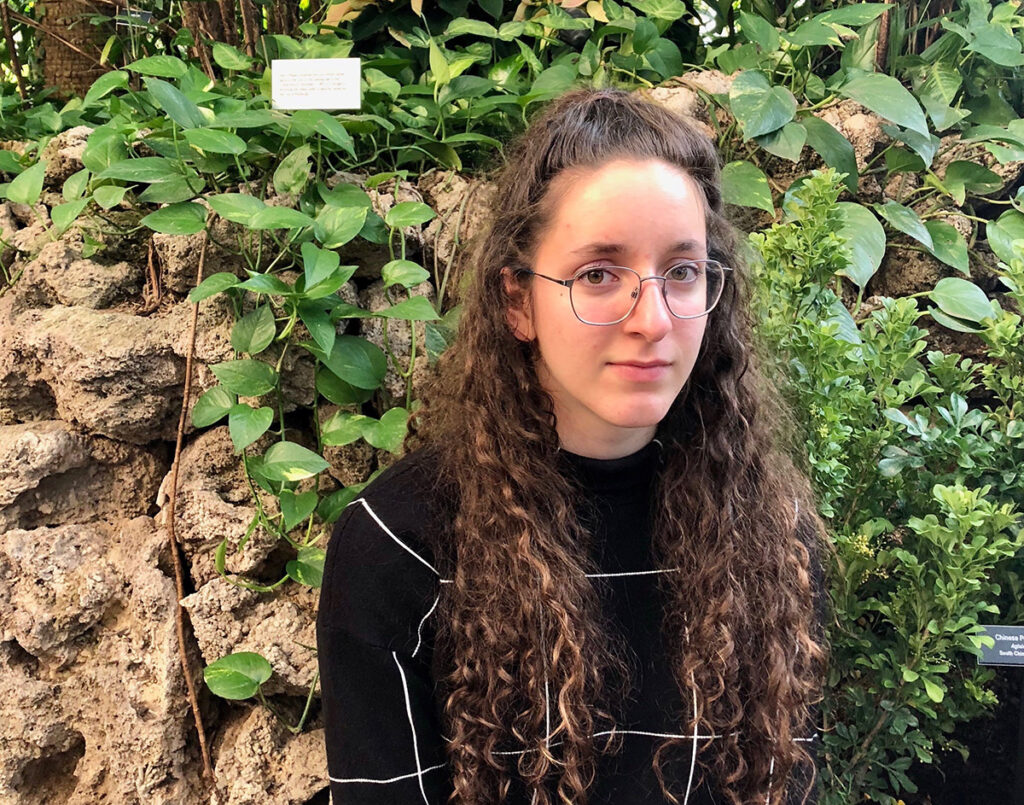 a person with long curly hair wearing glasses