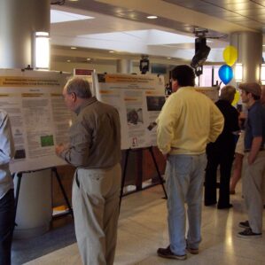 a group of people looking at posters in a dimly lit room