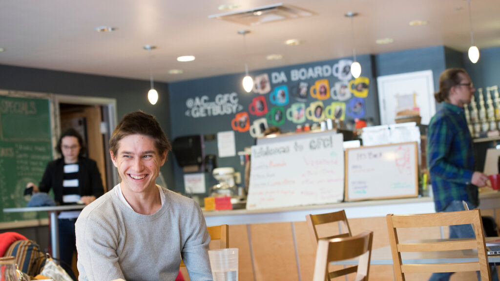 a smiling student sitting at a table