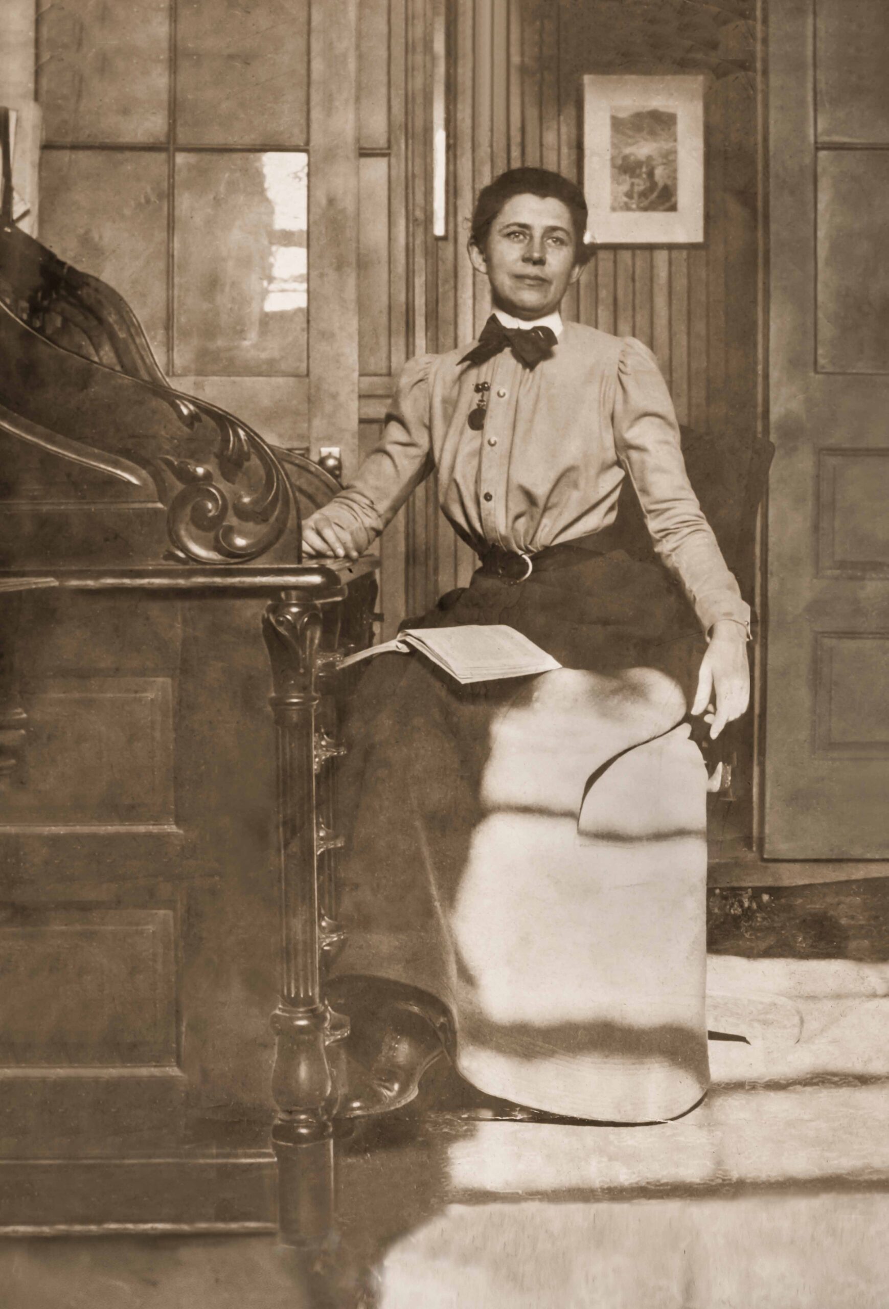Photograph of Ida Tarbell seated at her desk.