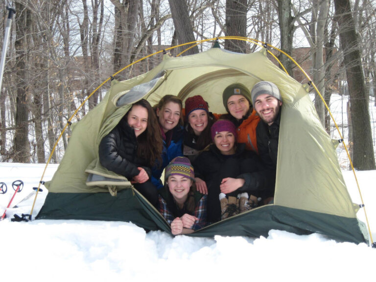 a group of students in a tent surrounded by snow