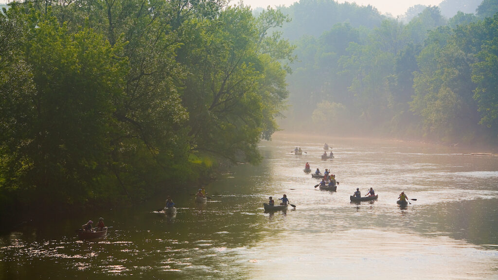 a group of students in boats on a river