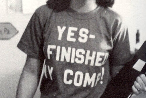 A historical black and white photo of a female student with a shirt reading 