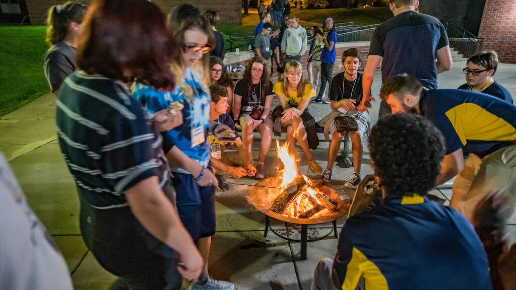 a group of students around a bonfire