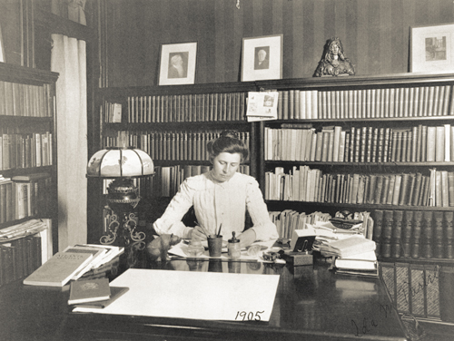 Historical black and white photo of Ida Tarbell sitting at a desk